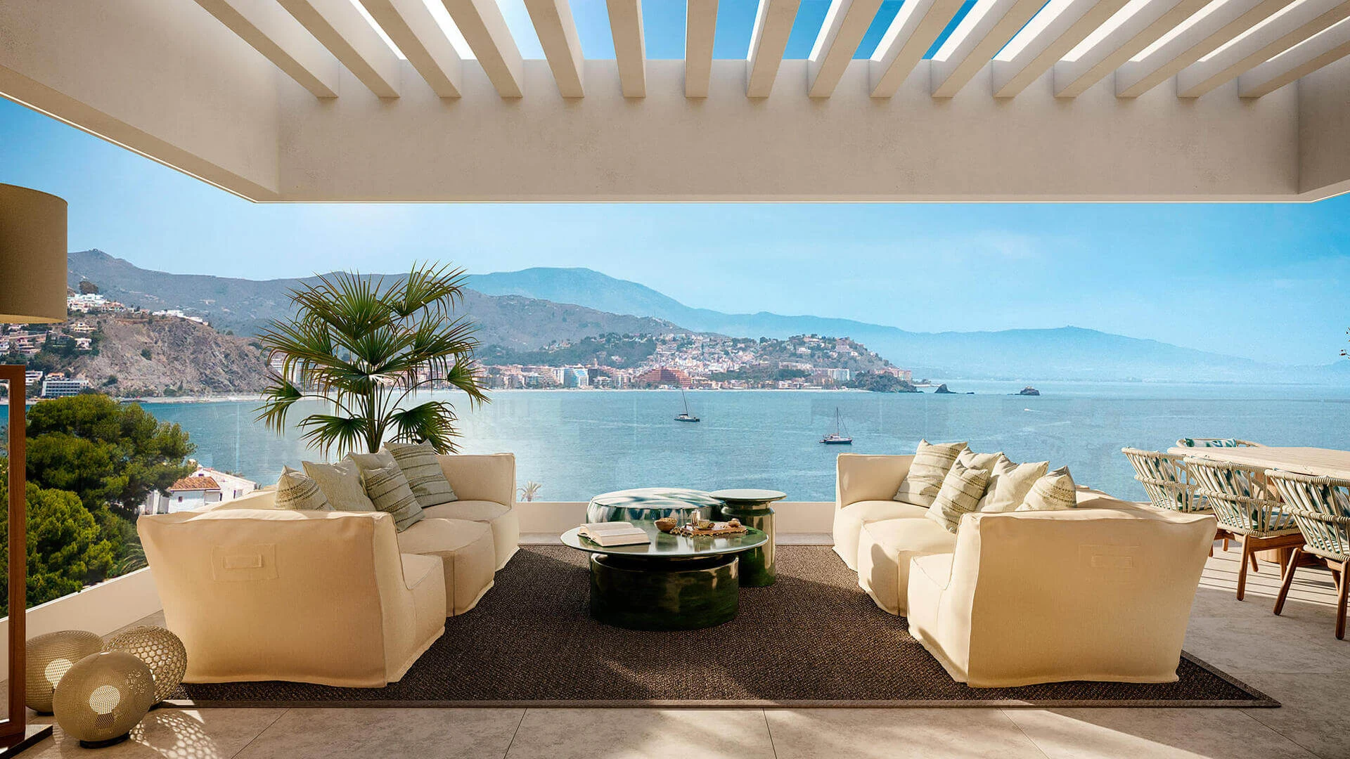 Overdekt terras met loungezetels en panoramisch zicht op de baai